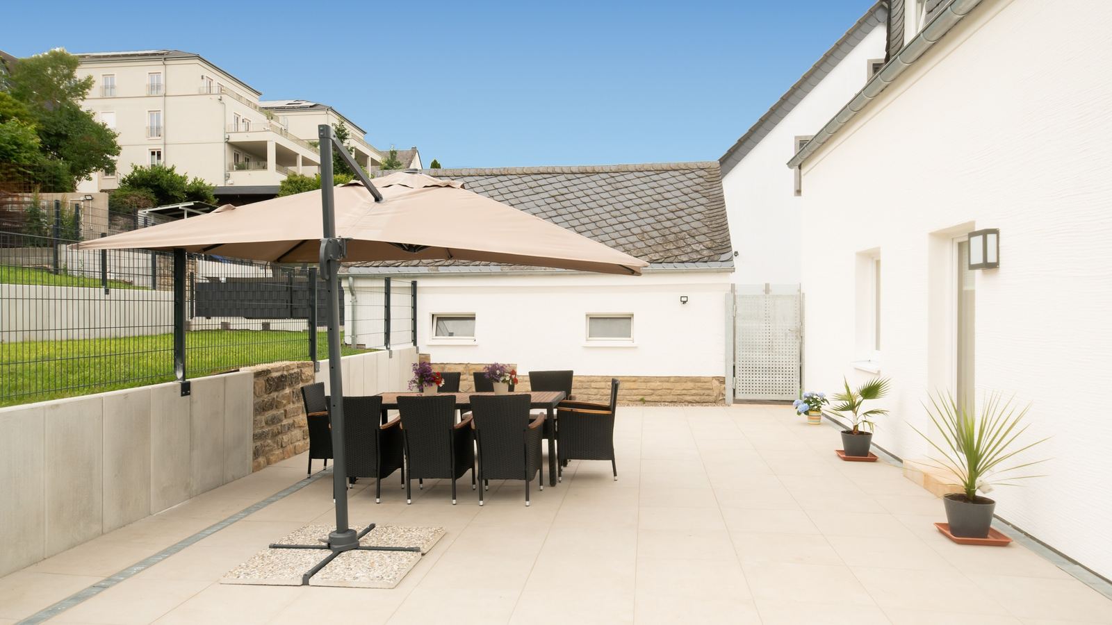 Sonnenterrasse mit großem Sonnenschirm und Essgruppe für 8 am frisch sanierten Ferienhaus